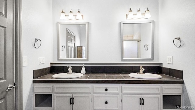 full bathroom featuring double vanity and a sink