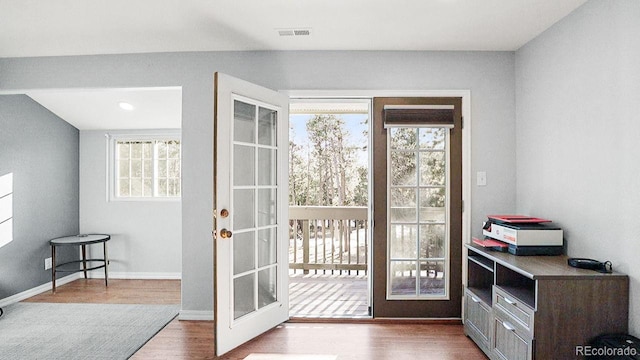 doorway to outside with wood finished floors, visible vents, french doors, and baseboards