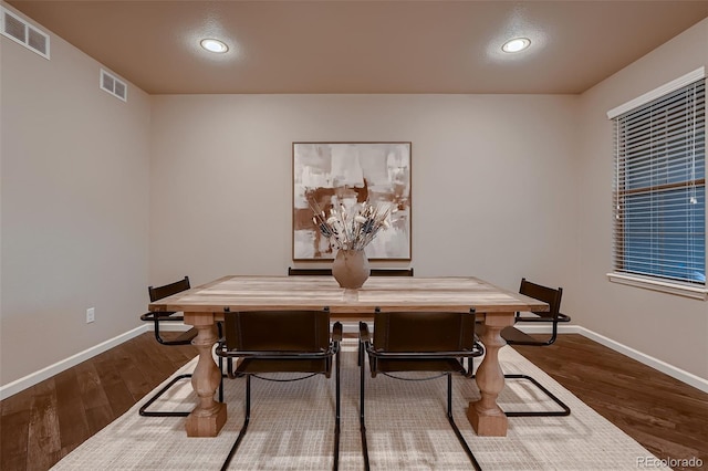 dining room featuring dark wood finished floors, visible vents, and baseboards