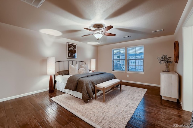 bedroom featuring wood-type flooring, visible vents, a textured ceiling, and baseboards