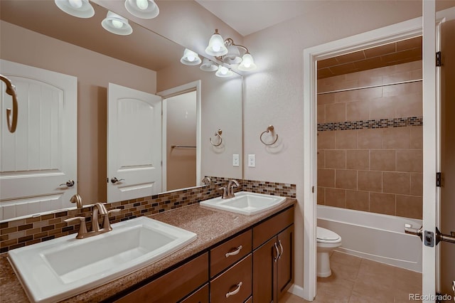 bathroom with tile patterned flooring, a sink, backsplash, and toilet