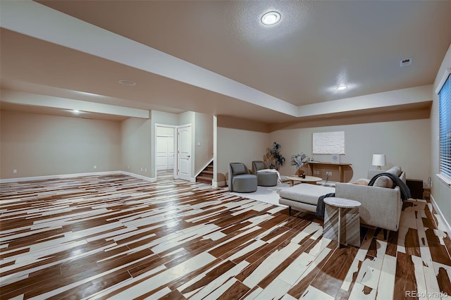 living area with baseboards, visible vents, stairway, and wood finished floors