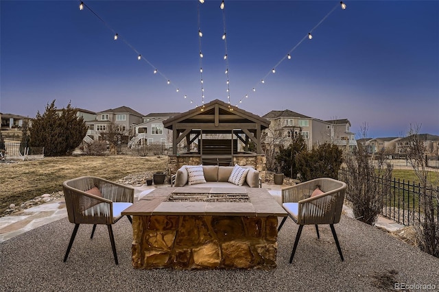 view of patio / terrace with a fire pit, fence, and a residential view