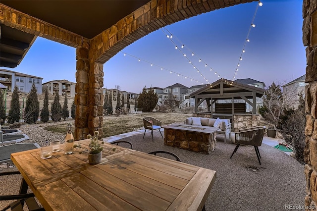 view of patio / terrace with an outdoor fire pit, outdoor dining area, a residential view, and a gazebo