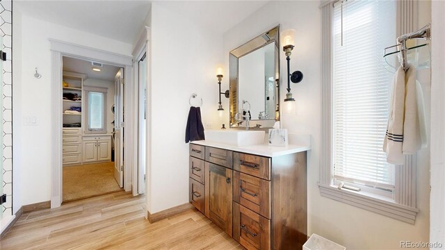 bathroom featuring visible vents, baseboards, vanity, and wood finished floors