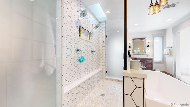 bathroom featuring vanity, recessed lighting, tiled shower, visible vents, and a skylight