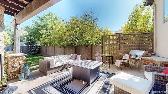 view of patio featuring a fenced backyard, outdoor lounge area, a grill, and exterior kitchen
