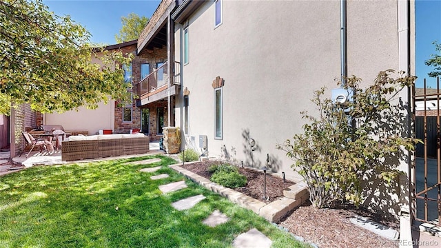 view of yard featuring a patio area, an outdoor living space, and a balcony