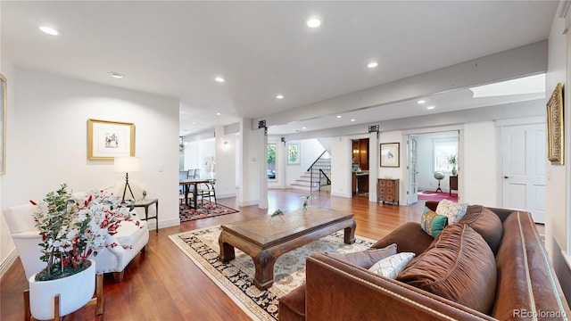 living area featuring baseboards, a barn door, recessed lighting, wood finished floors, and stairs