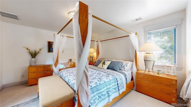 bedroom with visible vents, baseboards, and light carpet