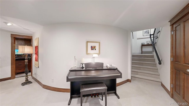 sitting room featuring stairs and baseboards