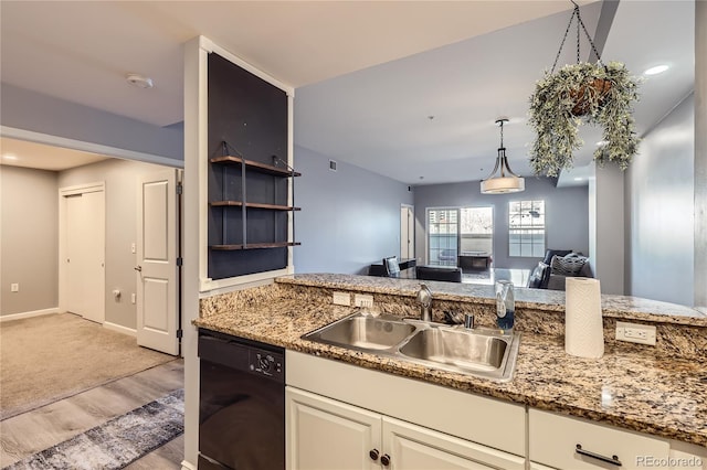 kitchen with black dishwasher, decorative light fixtures, light wood-style floors, a sink, and light stone countertops