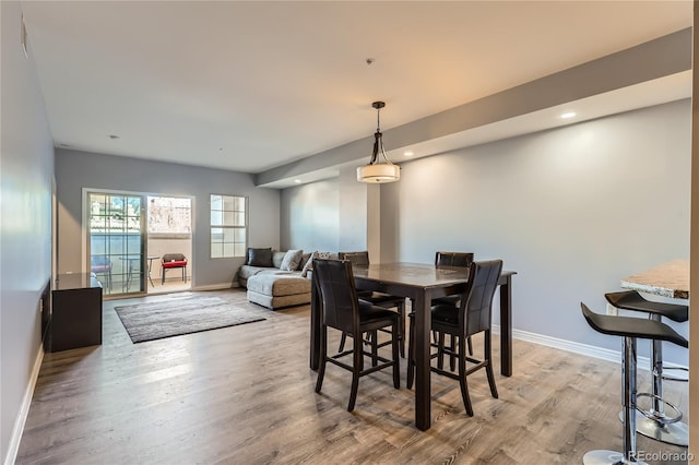 dining space featuring light wood finished floors, baseboards, and recessed lighting