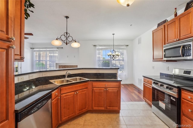 17442 Nature Walk Trl Unit 107, Parker, CO 80134 - kitchen featuring stainless steel appliances, a chandelier, pendant lighting, dark stone countertops, and light tile patterned flooring