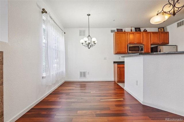 17442 Nature Walk Trl Unit 107, Parker, CO 80134 - kitchen with freestanding refrigerator, stainless steel microwave, brown cabinetry, wood finished floors, and a chandelier
