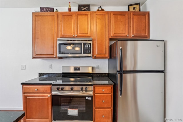 17442 Nature Walk Trl Unit 107, Parker, CO 80134 - kitchen featuring appliances with stainless steel finishes, brown cabinetry, and dark stone counters