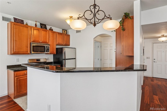 17442 Nature Walk Trl Unit 107, Parker, CO 80134 - kitchen featuring appliances with stainless steel finishes, wood finished floors, arched walkways, and brown cabinetry