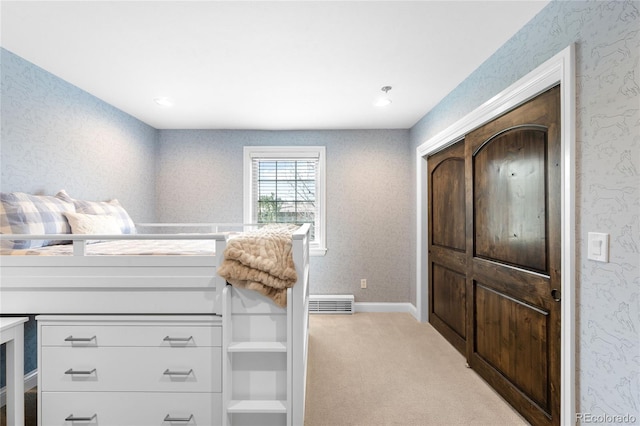 carpeted bedroom featuring wallpapered walls and visible vents