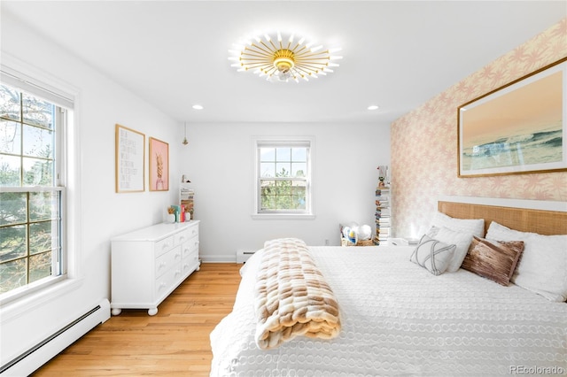 bedroom featuring light wood-style flooring, a baseboard radiator, and multiple windows