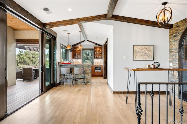 interior space featuring lofted ceiling with beams, plenty of natural light, visible vents, and a notable chandelier