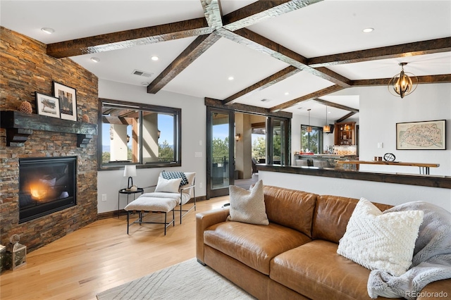 living room featuring a stone fireplace, lofted ceiling with beams, light wood-style floors, baseboards, and recessed lighting