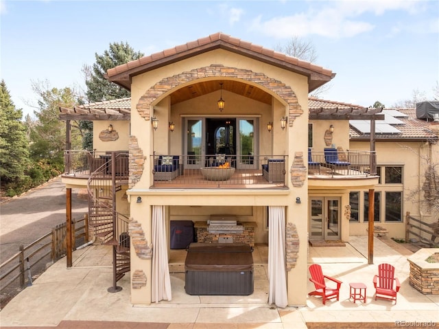 back of house with exterior kitchen, a tile roof, stairs, a balcony, and stucco siding