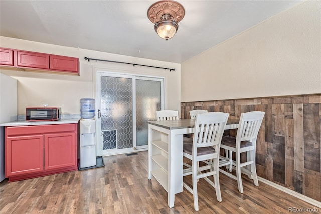 kitchen with open shelves, visible vents, wood walls, dark brown cabinets, and wood finished floors