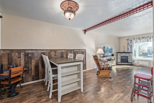 dining area with a fireplace, wood finished floors, and baseboards