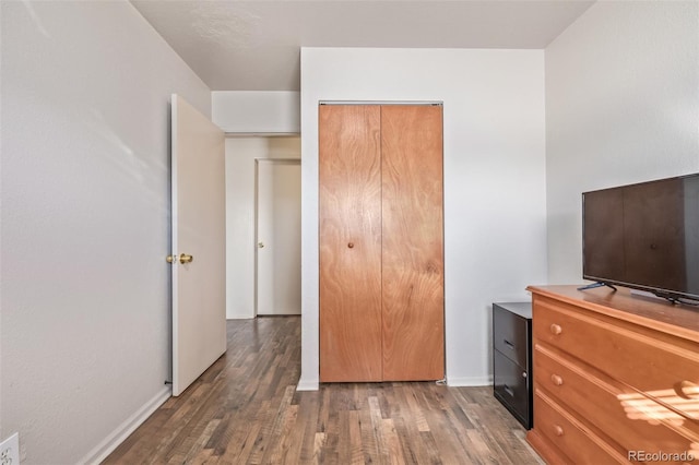 unfurnished bedroom with baseboards and wood finished floors