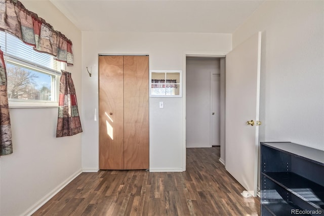 unfurnished bedroom featuring dark wood-style floors and baseboards