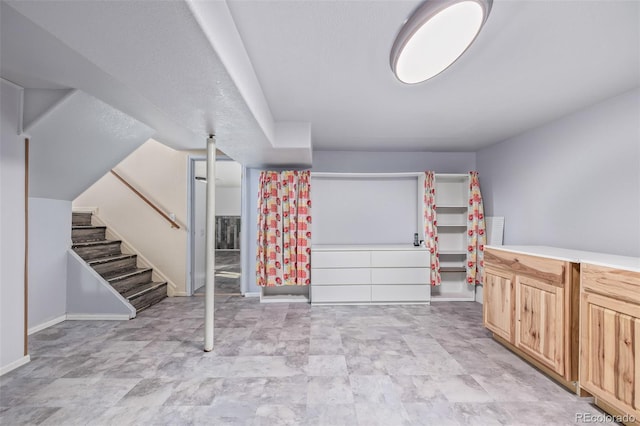 interior space featuring stairway and baseboards