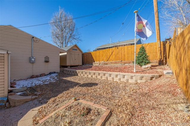 view of yard featuring a shed, a fenced backyard, and an outbuilding