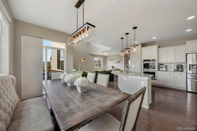 dining space featuring recessed lighting, a chandelier, and dark wood-type flooring