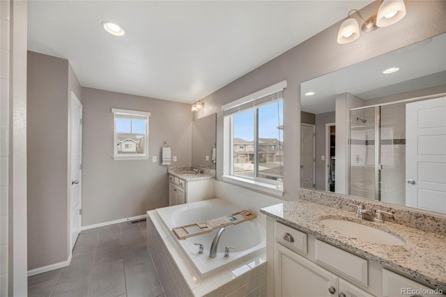 bathroom with a sink, a bath, a stall shower, and a wealth of natural light