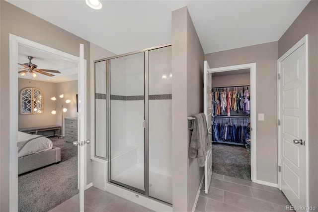 ensuite bathroom featuring baseboards, connected bathroom, tile patterned floors, a shower stall, and a ceiling fan