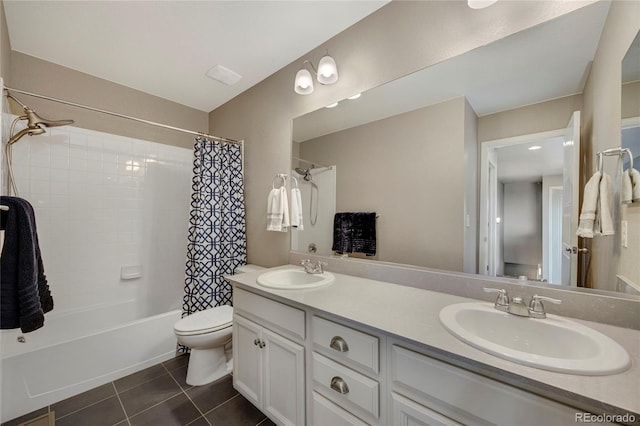bathroom with tile patterned flooring, a sink, double vanity, and toilet