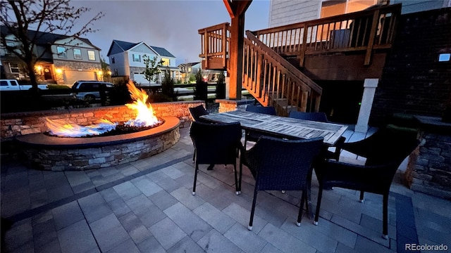 view of patio / terrace with stairway, outdoor dining space, and an outdoor fire pit