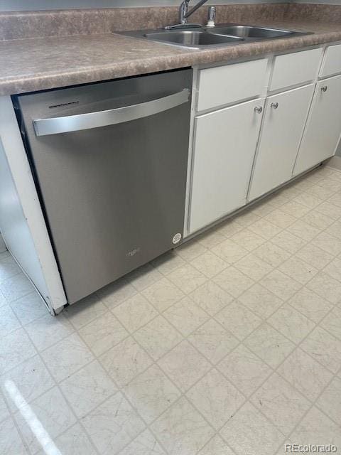 kitchen with dark countertops, white cabinetry, dishwasher, and light floors