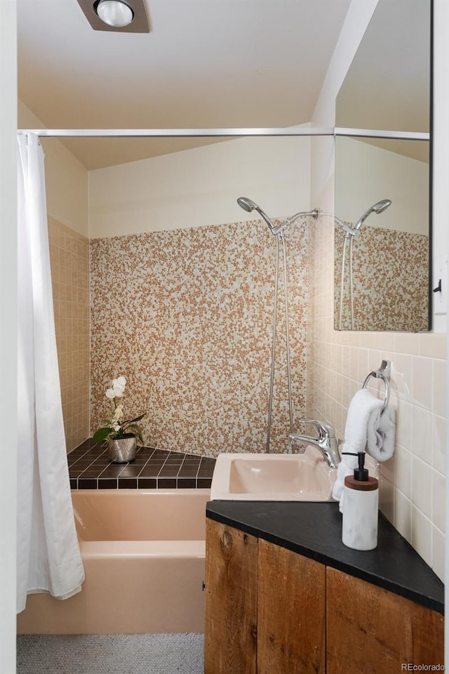 bathroom with vanity, shower / tub combo, decorative backsplash, and tile walls