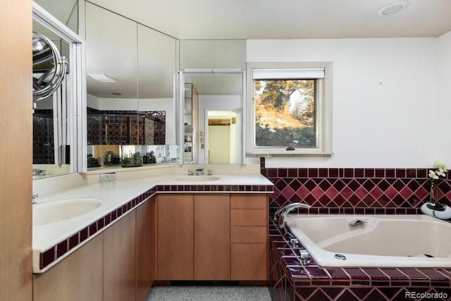 bathroom featuring a relaxing tiled tub and vanity