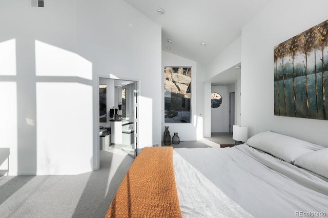 carpeted bedroom with high vaulted ceiling