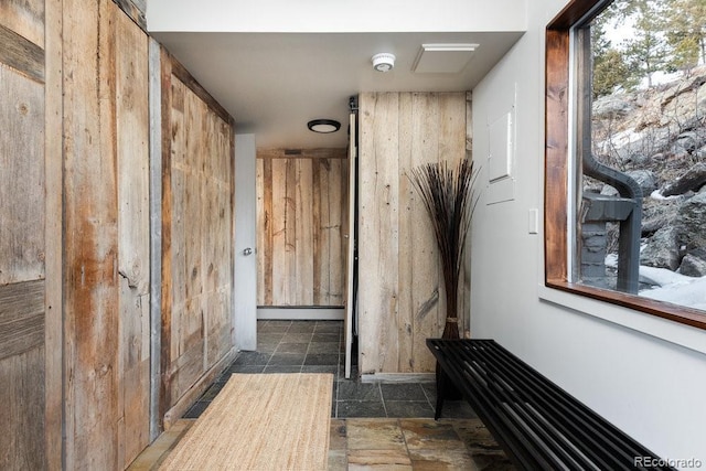 corridor featuring stone finish floor and a baseboard radiator