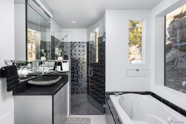 full bath featuring a bath, a stall shower, and vanity