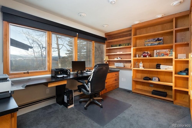 office space featuring baseboard heating and dark carpet