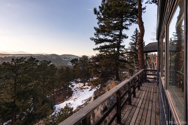 deck at dusk featuring a mountain view