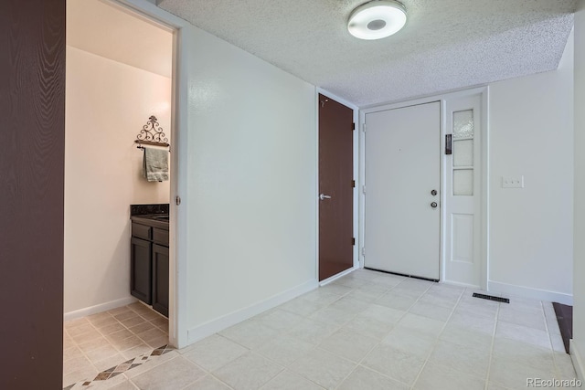 tiled foyer featuring a textured ceiling