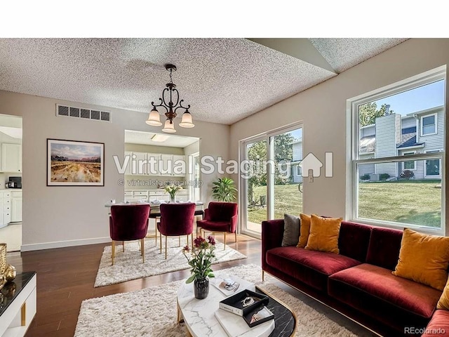 living room featuring a textured ceiling, dark hardwood / wood-style flooring, and a chandelier