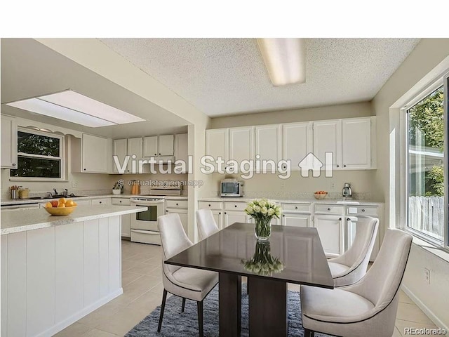 dining space featuring a textured ceiling and light tile patterned floors