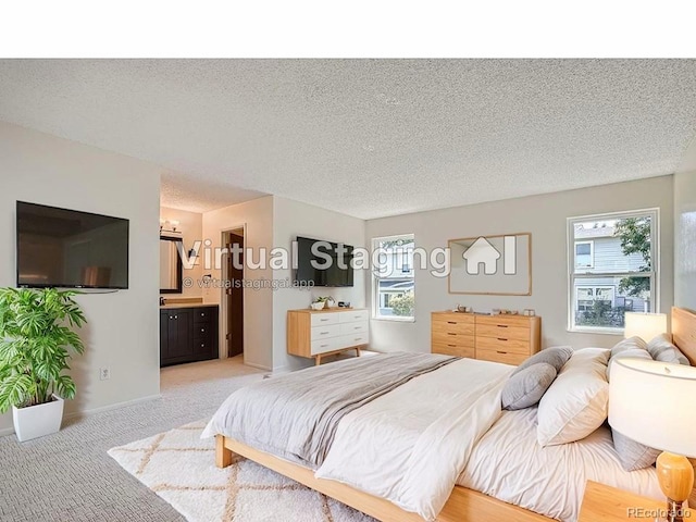 carpeted bedroom featuring connected bathroom and a textured ceiling