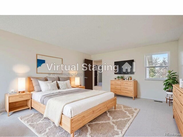 bedroom with light carpet and a textured ceiling